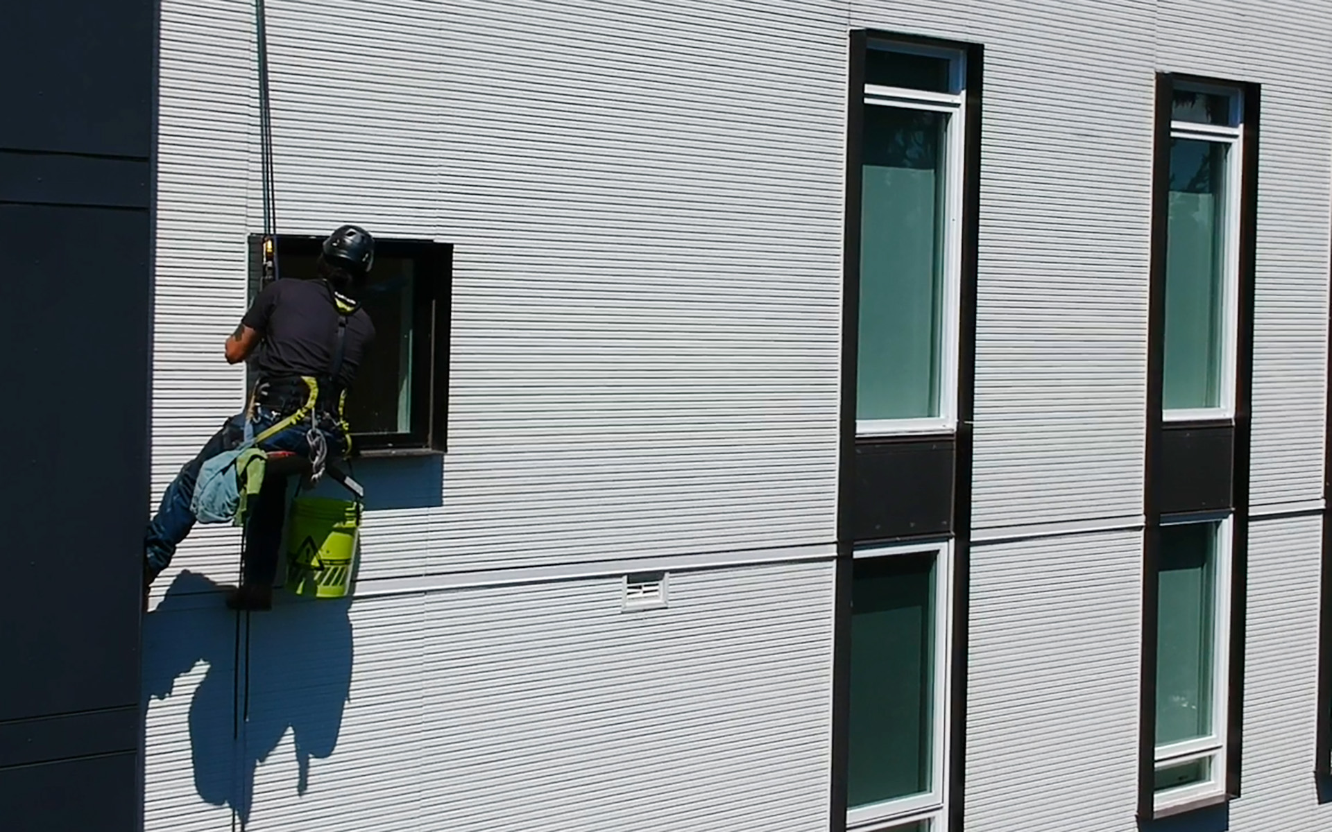 Chimera Rope Access Employee washing window on Boatswains chair